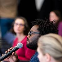 A student asks a question after a presentation.